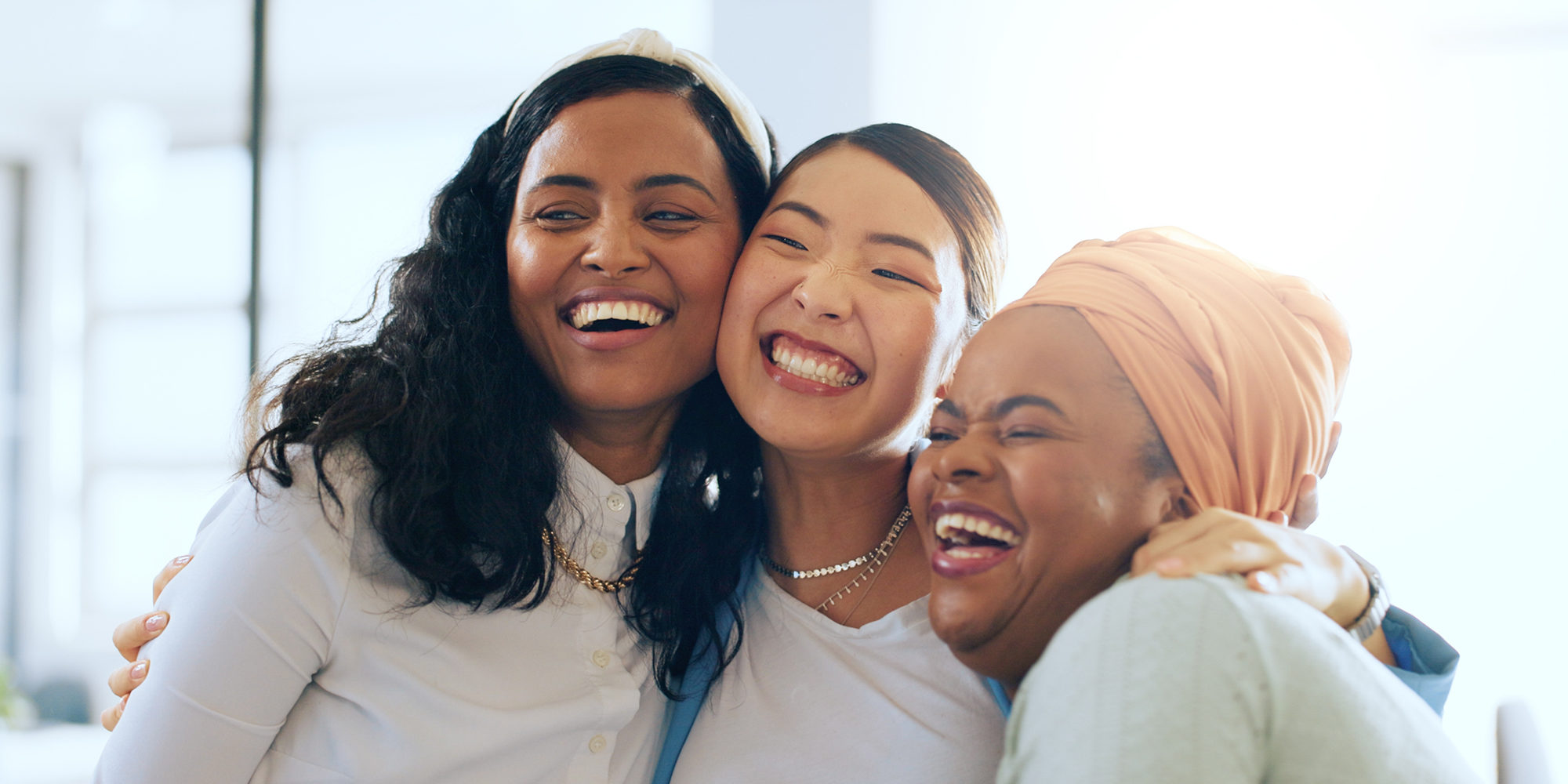 Women, happy and hug with celebration and team, diversity and success in presentation and collaboration. Solidarity, trust and business people, happiness and win in successful business meeting.